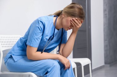 Exhausted doctor sitting on chair in hospital