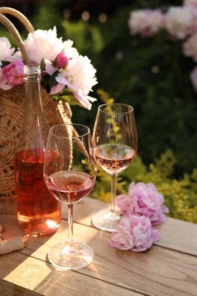 Μπουκάλι Και Ποτήρια Ροζέ Κρασί Κοντά Όμορφες Παιώνιες Ξύλινο Τραπέζι — Φωτογραφία Αρχείου