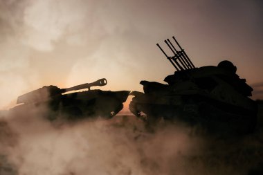 Silhouettes of armored fighting vehicle and tank on battlefield
