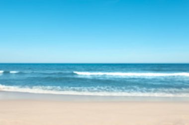 Güneşli bir günde bulanık deniz ve kumlu plaj manzarası