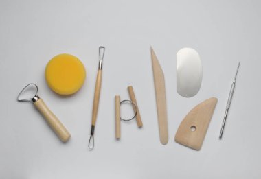 Set of clay modeling tools on white background, flat lay