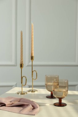Beyaz masada, mumların yanında şarap kadehleri