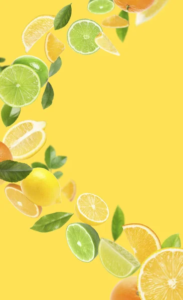 Fresh Juicy Citrus Fruits Green Leaves Falling Yellow Background — kuvapankkivalokuva
