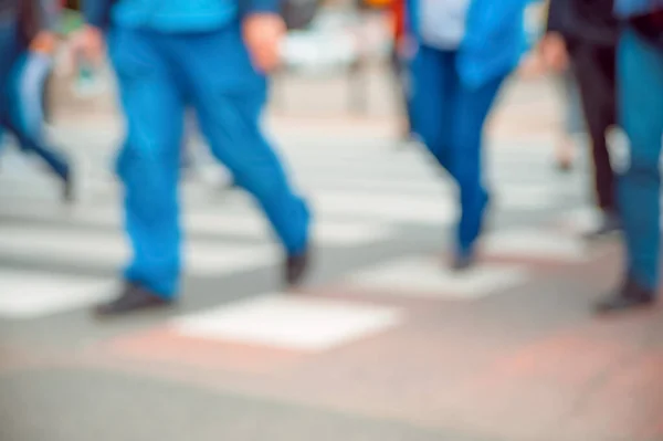 People crossing street outdoors, closeup. Blurred view