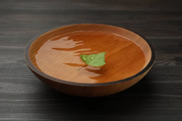 Bowl Water Green Leaf Dark Wooden Table Closeup — Fotografia de Stock