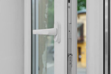 Open window with white plastic frame indoors, closeup