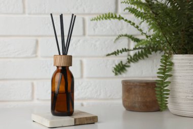 Air reed freshener on table against white wall