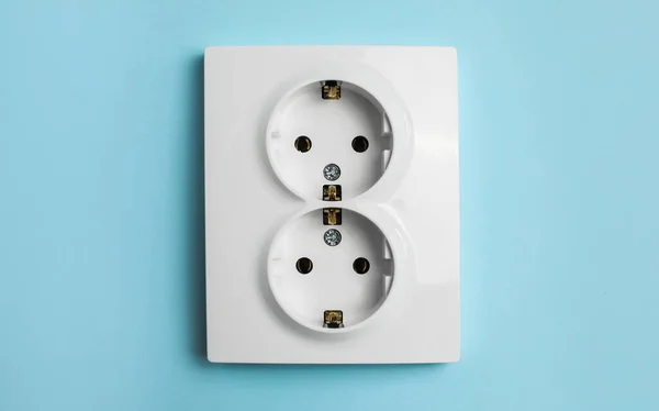 Double power socket on light blue wall. Electrical supply