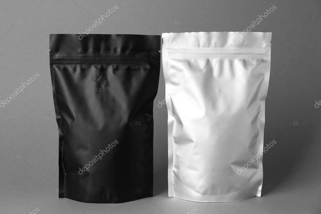 Different blank foil packages on grey background