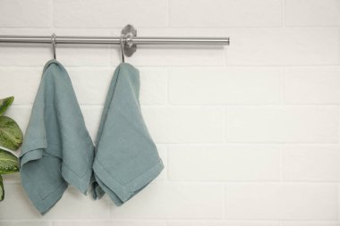 Clean kitchen towels hanging on rack. Space for text