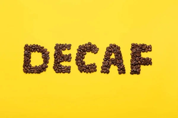 Word Decaf Made Coffee Beans Yellow Background Flat Lay — Stockfoto