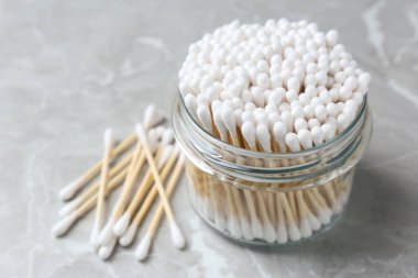 Many cotton buds on light grey marble table