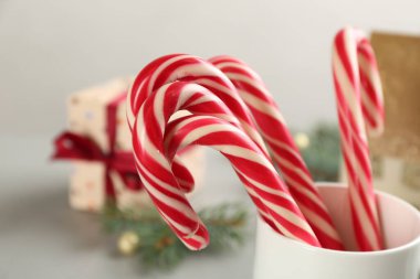 Sweet Christmas candy canes in cup, closeup view