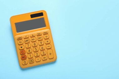Orange calculator on turquoise background, top view. Space for text