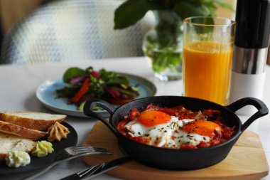 Lezzetli Shakshouka beyaz masada servis yapıyor. Geleneksel Arapça yemek