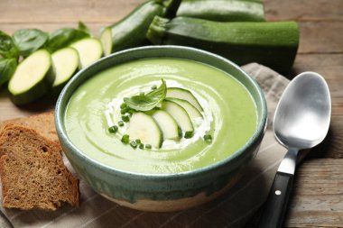 Ahşap masada servis edilen lezzetli ev yapımı kabak kremalı çorba.