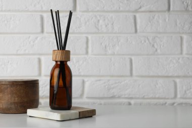 Air reed freshener on table against white wall. Space for text