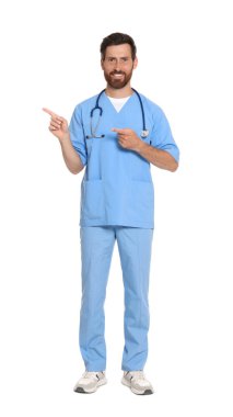 Full length portrait of doctor in scrubs on white background