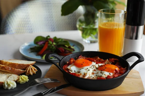 Lezzetli Shakshouka beyaz masada servis yapıyor. Geleneksel Arapça yemek