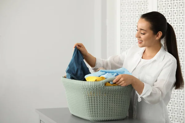 Young Woman Basket Full Clean Laundry Table Indoors — Stockfoto