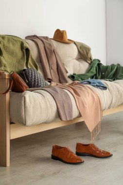 Oturma odasındaki kanepede dağınık giysi ve aksesuarlar.