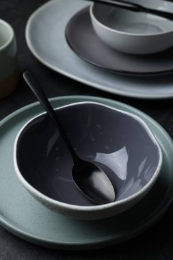 Set of clean tableware on black table