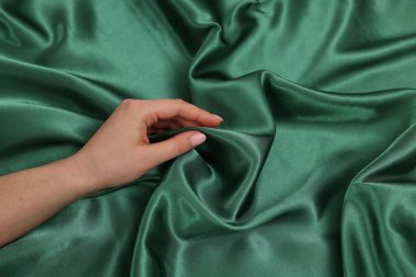 Yumuşak ipek kumaşa dokunan kadın, yakın çekim görüntüsü.