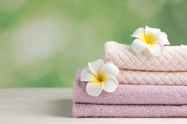 Closeup View Soft Folded Towels Plumeria Flowers White Wooden Table — Stock Fotó