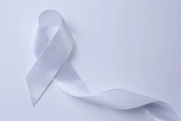 White Awareness Ribbon White Background Top View — Fotografie, imagine de stoc