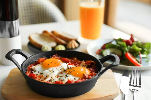 Lezzetli Shakshouka beyaz masada servis yapıyor. Geleneksel Arapça yemek