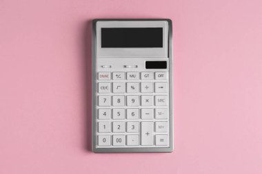 Pembe arkaplanda beyaz hesap makinesi, üst görünüm