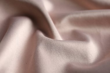 Arkaplan olarak narin pembe kumaş dokusu, yakın plan