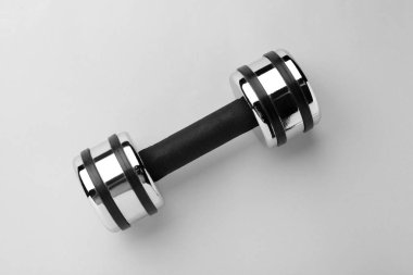 Metal dumbbell on light background, top view
