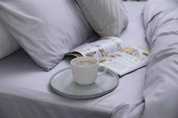 Tasse Kaffee Und Magazin Auf Dem Bett Mit Weicher Seidiger — Stockfoto
