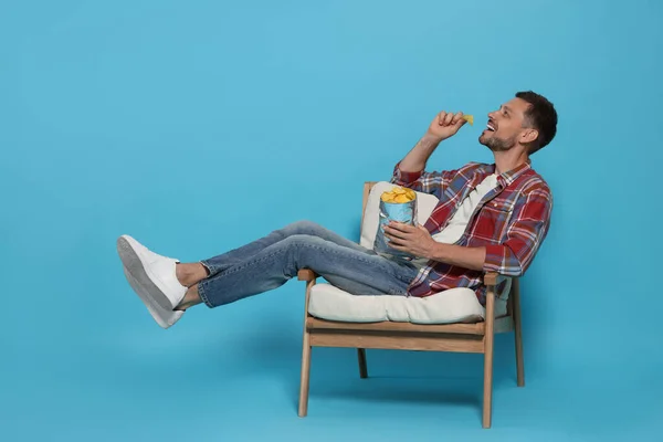 Handsome Man Eating Potato Chips Light Blue Background — 스톡 사진