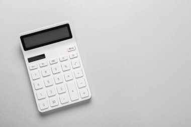 White calculator on light background, top view. Space for text
