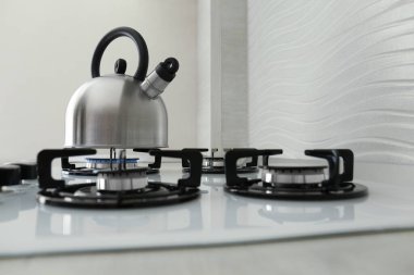 Kettle on modern gas stove in kitchen