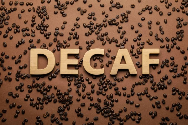 Word Decaf Made Wooden Letters Brown Background Coffee Beans Flat — Stockfoto