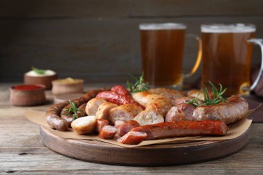 Farklı lezzetli atıştırmalıklar ve ahşap masada bira.