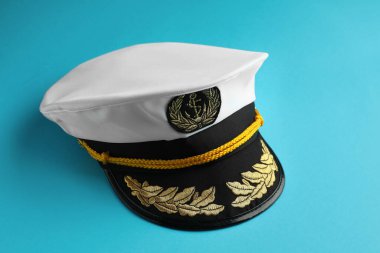 Peaked cap with accessories on light blue background