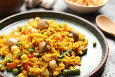 Delicious rice pilaf with vegetables on table, closeup