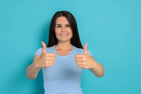 Young Woman Showing Thumbs Light Blue Background — Stock Fotó