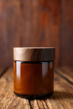 Jar of luxury cream on wooden table, closeup