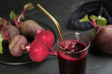 Freshly made beet juice on black table, closeup view