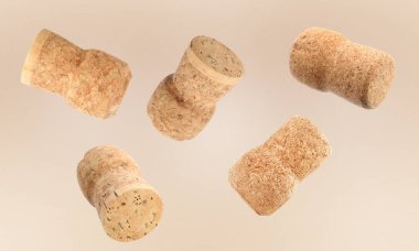 Many corks of sparkling wine bottles falling on light background