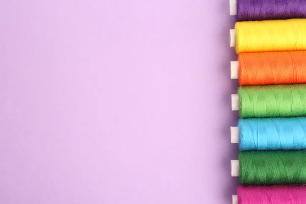 Diversi Fili Colorati Cucire Sfondo Lilla Posa Piatta Spazio Testo — Foto Stock
