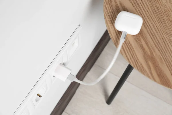Modern Wireless Earphones Charging Electric Socket Indoors View — Fotografia de Stock