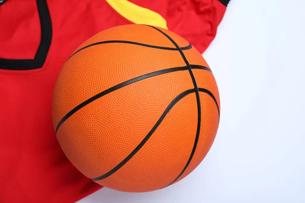 Basketball uniform and ball on white background, top view