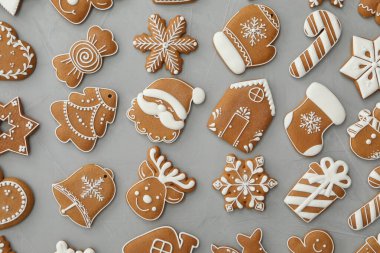 Gri arka planda farklı Noel kurabiyeleri, düz yatış