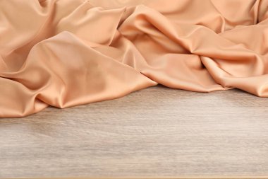 Ahşap masada güzel şeftali rengi ipek, yazı için yer